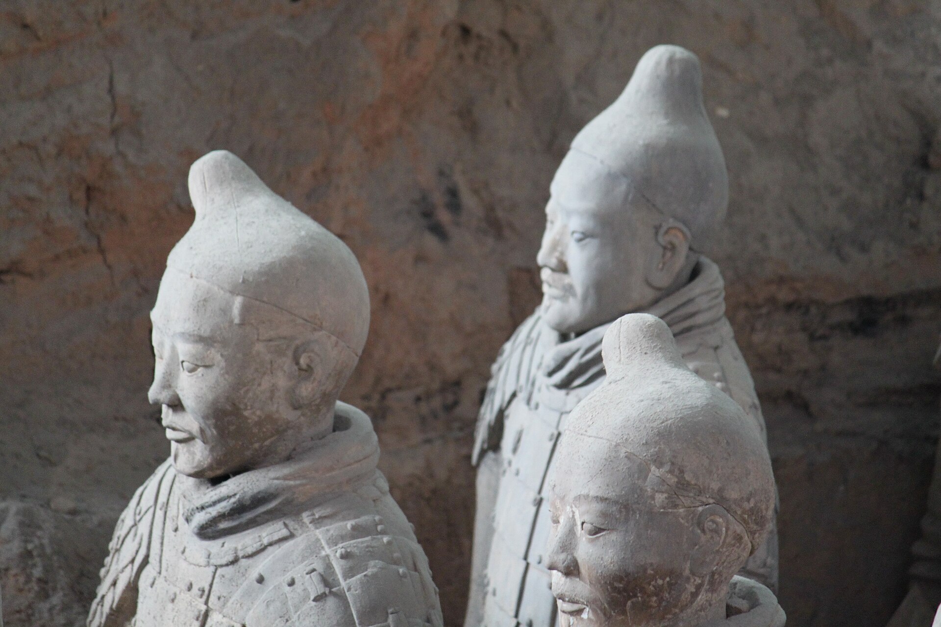 Terracotta warriors in identical armour and caps — individuals absorbed into the ranks of a Qin dynasty army